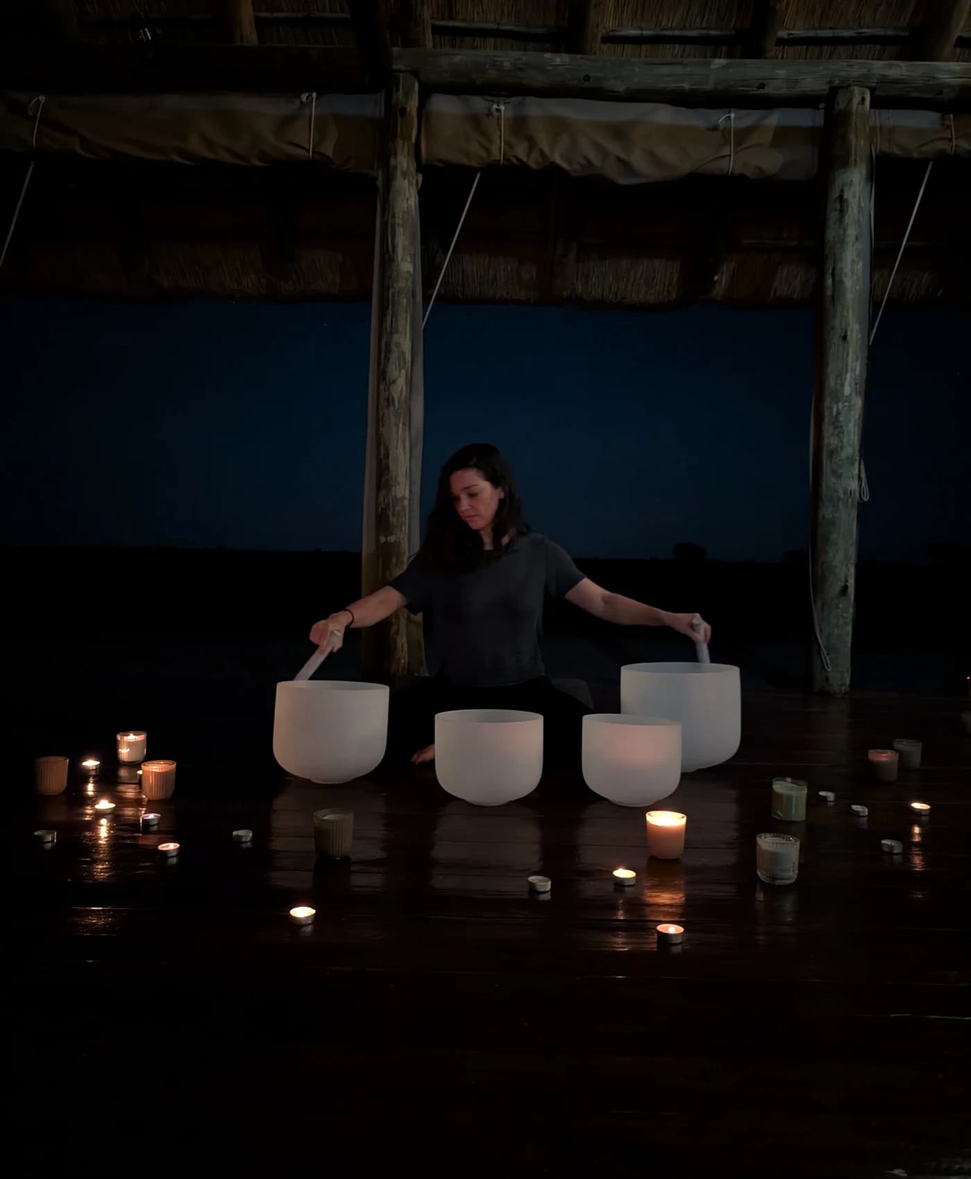 A candlelit crystal sound bowl session in the shala after dark