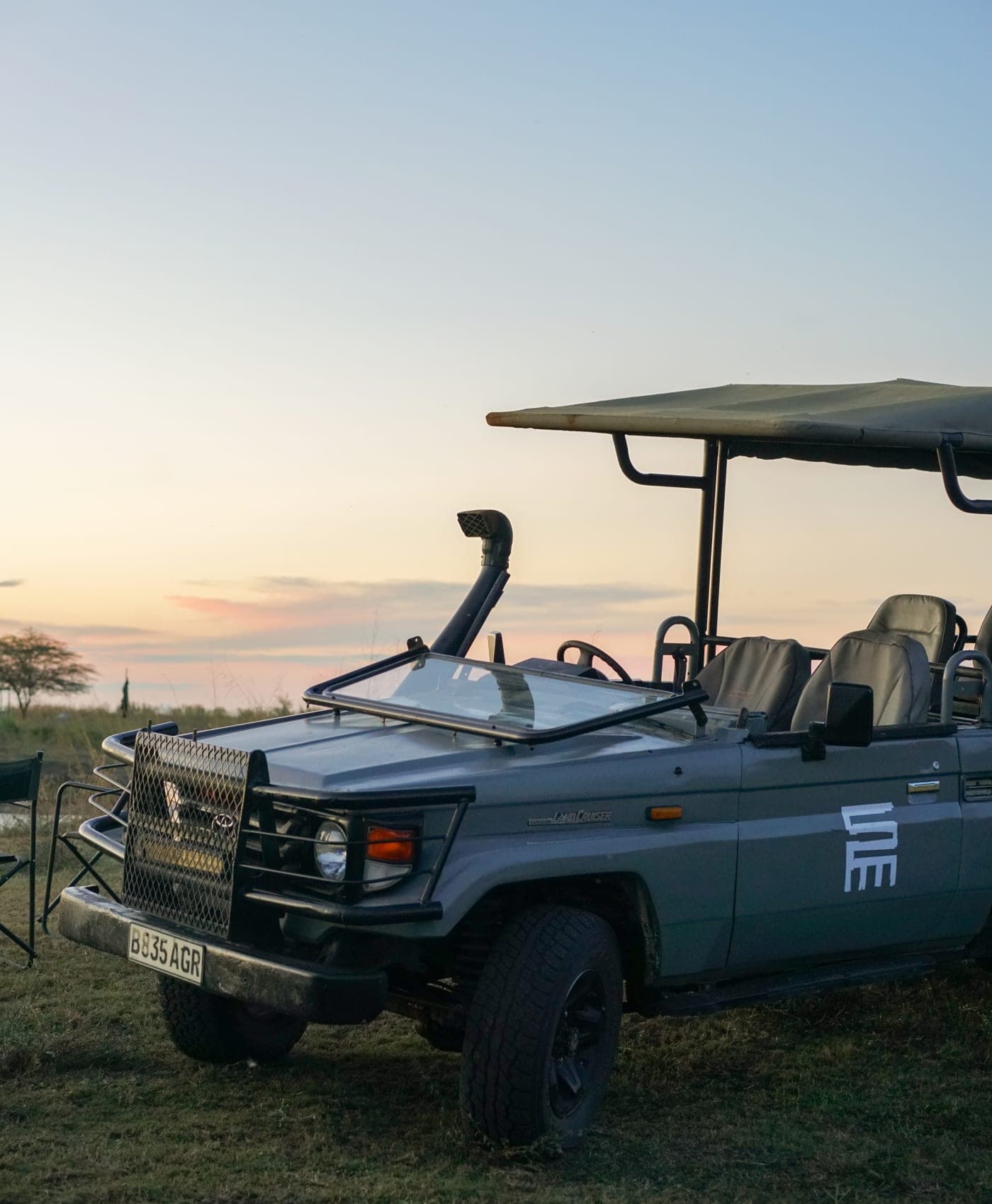 An open safari vehicle waiting at first light before a game drive